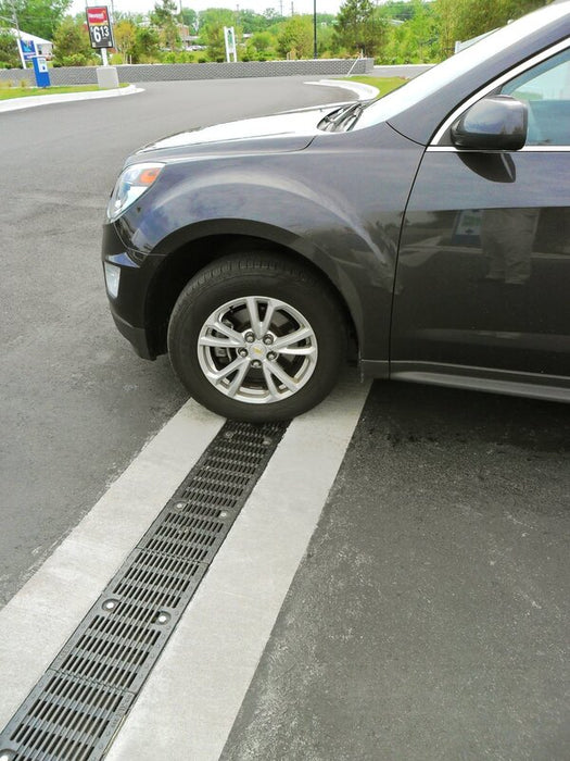 SUV parked over an ACO FG200 trench drain at a gas station
