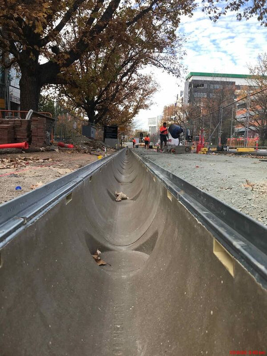 ACO K300 polymer concrete channel being installed along a city street
