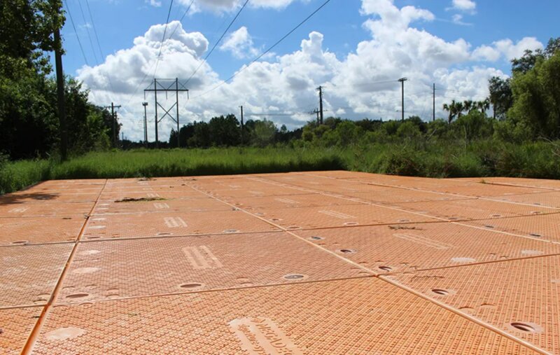 Large MegaDeck HD+ ground protection mat platform laid out across an open field jobsite
