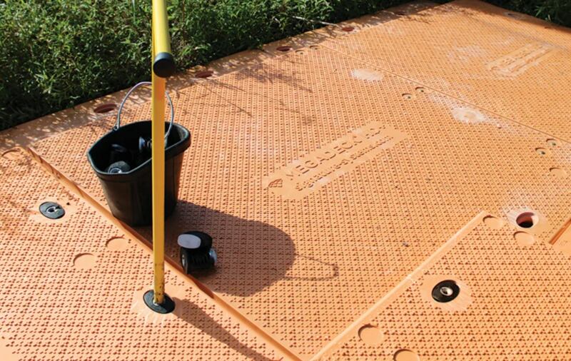 Close-up of MegaDeck HD+ ground protection mat connecting holes and hardware in the field
