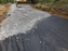 Non-woven geotextile fabric separating soil from gravel on an access road
