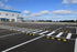 Rows of black and yellow rubber parking stops installed across a large commercial parking lot

