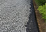 Woven geotextile fabric visible at the edge of a finished gravel driveway
