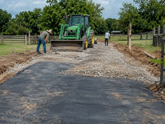 Woven geotextile fabric forming a stabilized driveway base
