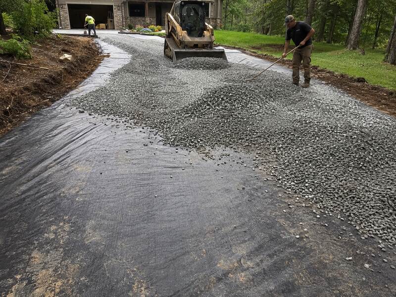 Woven geotextile fabric driveway installation with gravel
